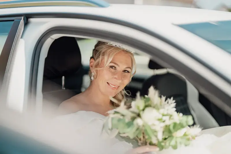 Die Braut lächelt vor der Trauung aus dem Auto